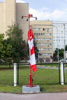 Moscow, Moscow region, Russia - 03.09.2023.A striped wind direction indicator wrapped around its pole on the airfield with buildings in the background photo