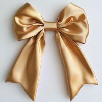 Elegant golden satin bow with flowing ribbon on white background photo
