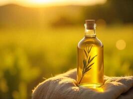 A bottle of olive oil with a cork stopper and a rosemary branch inside, on a burlap cloth, in a field at sunset photo
