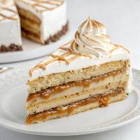 A slice of Rogel cake with multiple layers of dulce de leche and a caramelized meringue topping, displayed on a clean white background photo