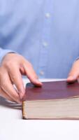 vertical Hands reading an open book on a table video