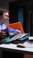 vertical Office worker struggling with excessive paperwork at computer desk video