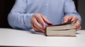 Hands reading an open book on a table video