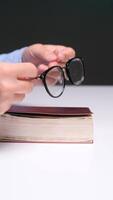 vertical mãos segurando aberto livro em branco mesa video