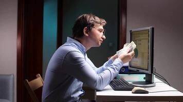 Office worker comparing banknotes with computer screen information video