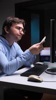 vertical Office worker comparing banknotes with computer screen information video