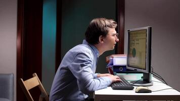 Office worker with bad posture typing on keyboard and looking at computer screen video
