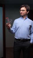 vertical Office worker holding small shopping cart reflecting on purchases and consumerism video