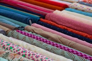 Colorful Fabrics Rolled Up, Displaying Various Patterns and Textures for Sewing and Fashion Design photo