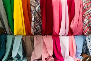 Colorful fabrics hanging in a store, textile industry and retail concept photo