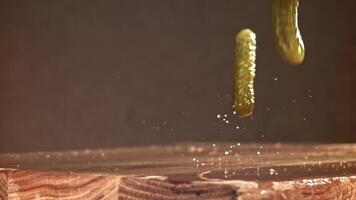 Pickled cucumbers fall on a wooden table. Filmed on a high-speed camera at 1000 fps. High quality FullHD footage video
