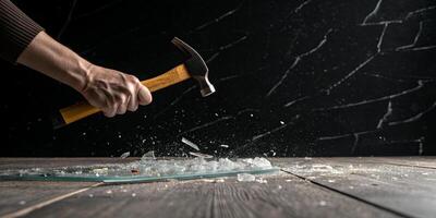 Impact with a hammer breaking glass for business concepts of destruction and failure photo
