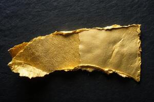 Torn piece of gold paper on a dark background for business applications and creativity photo