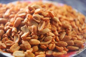 Roasted peanuts served on a colorful plate at a local market photo