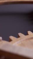 Looping animation of a mechanical construction made of wooden gears. Cyclic movement. Vertical composition. Defocus. video
