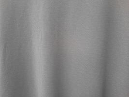 A close-up image of a smooth grey fabric with subtle vertical folds, giving it a soft and elegant appearance photo