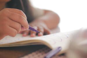 Child drawing in a notebook with colorful markers during afternoon photo