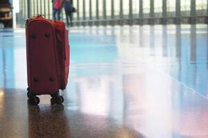 Lone suitcase waiting at airport terminal during busy travel hours photo