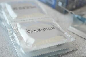 condom packet display manufacturing and expiration dates on surfaces photo