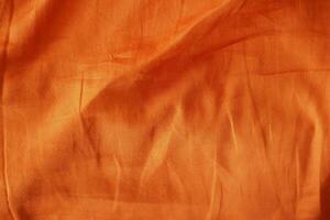 Bright orange fabric with smooth texture and subtle wrinkles photo