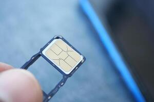 Holding a sim card near a smartphone for connection setup photo