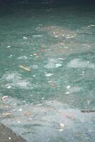 Pollution seen in a water body with garbage and debris floating photo