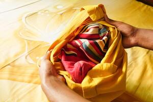 man putting a pillow case in a pillow photo