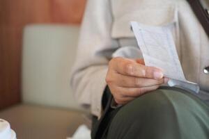 Person holding a receipt while sitting in a cozy cafe space photo