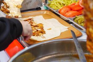 Making delicious shawarma wraps at a busy market stall photo
