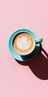Turquoise cup of latte art on pale pink surface for modern coffee aesthetic photo