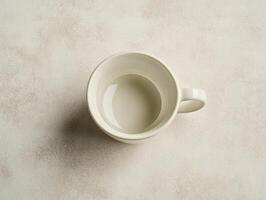 Minimalist flat lay top view of white espresso cup on neutral surface photo