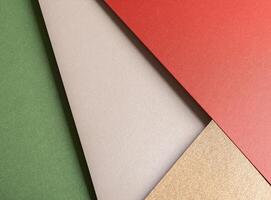 Paper background with matte texture. Layered diagonal sheets in crimson red, champagne, soft beige, photo