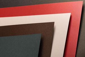 Paper background with matte texture. Fan spread composition with layered sheets in crimson red, pine photo