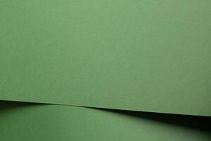 Paper background with matte texture. Folded layered sheets in pastel green, sage green, and subtle photo