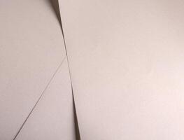 Paper background with satin pearlescent texture. Matte folded layers, smooth surface in pale gold photo