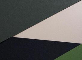 Paper background with matte texture. Layered geometric surface in soft beige, champagne, pine green, photo