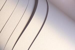 Paper background with satin pearlescent texture. Glossy folded strips, smooth layered surface in photo