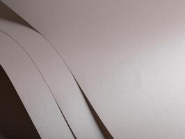 Paper background with satin pearlescent texture. Folded layered surface, smooth matte and glossy photo