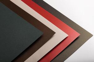 Paper background with matte texture. Layered diagonal sheets in crimson red, soft beige, champagne, photo