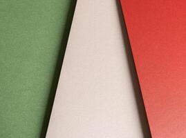 Paper background with matte texture. Vertical layered sheets in crimson red, pastel green, mint photo