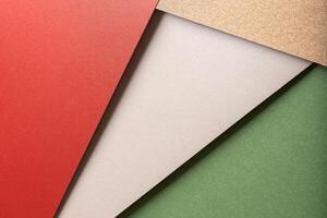 Paper background with matte texture. Layered diagonal sheets in bright red, champagne, metallic photo
