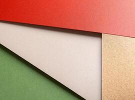 Paper background with matte texture. Layered diagonal sheets in bright red, pastel green, champagne, photo
