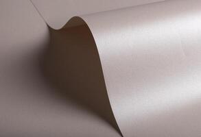 Paper background with satin pearlescent texture. Glossy curved folds, smooth sculptural surface in photo