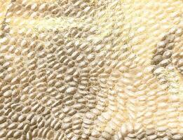 Golden metallic texture with embossed, shimmering pattern. Luxurious, opulent surface, rich in photo