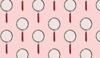 Magnifying glasses arranged in a repeating pattern, symbolizing exploration, examination, and photo