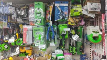 Dnipro, Ukraine - April 26, 2025 - Variety of hand tools and accessories displayed on hardware store shelf featuring pliers, scissors, lock, and tape. concept of diy projects, home repairs photo