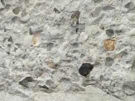 Close-up of concrete texture with aggregate stones and rough surface. photo