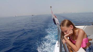 Young female traveler leaning against boat railing, gazing thoughtfully across expansive Red Sea waters during scenic summer maritime journey video