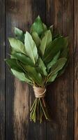 Bouquet of fresh green leaves on a wooden background photo