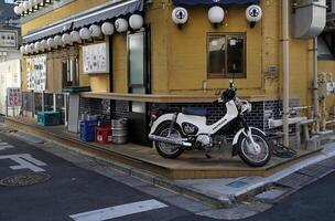 Tokyo, Japan - 12 January 2025 - A moped stands on the corner of a street in Tokyo photo
